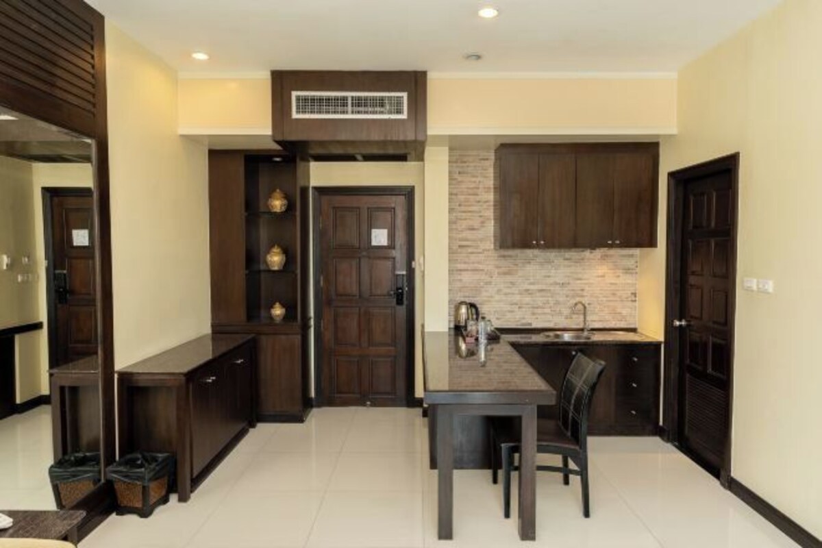Una cocina compacta con alacenas de madera oscura, una isla central y una estufa integrada.