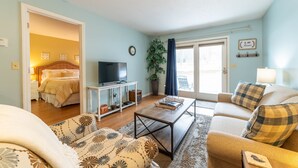 A living room with a sofa, a coffee table, a TV, and a plant. - Hidden Gem in Walloon Village (Walloon Lake)