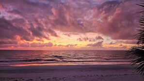Een strand met een zonsondergang en golven.