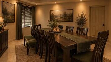 A dining room with a long wooden table, multiple chairs, a bench, and two potted plants.