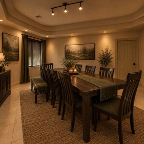 A dining room with a long wooden table, multiple chairs, a bench, and two potted plants.