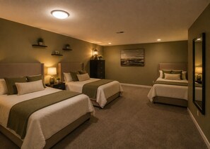 A hotel room with two beds, a nightstand with a lamp, a painting on the wall, and a ceiling light.