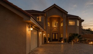 A large, two-story house with a covered driveway and multiple garage doors.