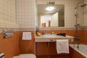 A bathroom with a sink, mirror, and shower.