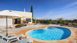 A swimming pool with lounge chairs and a covered area. - Villa with pool and sea view.  Quiet location, beach and restaurants nearby. (Carvoeiro)