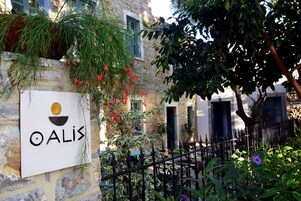 Un edificio de piedra con un letrero que dice "OALIS" y una cerca de hierro forjado.