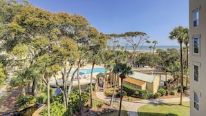 Ein Resort mit Pool, Palmen und Blick auf den Ozean.
