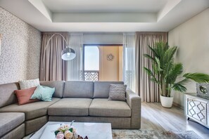 Appartement supérieur, 3 chambres, vue sur la mer, en face de la plage | Aire de séjour | Téléviseur connecté de 65 po avec télévision par satellite, téléviseur