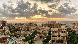 Zona residencial con varias edificaciones de dos pisos, una piscina y vista al mar.