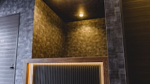 Un intérieur moderne avec un mur lambrissé en bois, des spots encastrés au plafond et un motif de lattes verticales en bois.