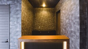 Une salle de bain moderne avec un meuble-lavabo en bois, des murs à texture et des spots encastrés au plafond.