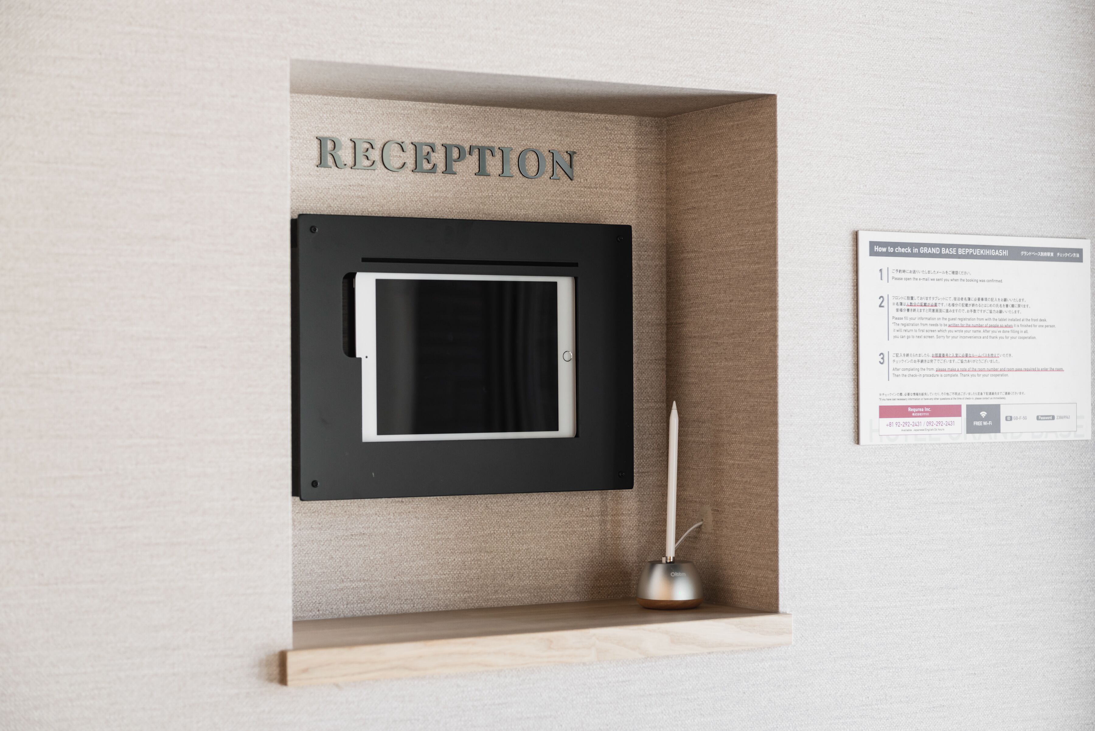 A reception area with a framed window, a reception desk, and a sign with instructions.