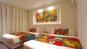A hotel room with two beds, each with colorful bedding, a large abstract painting above the beds, and a window with curtains. - Bond Base (Fukuoka)