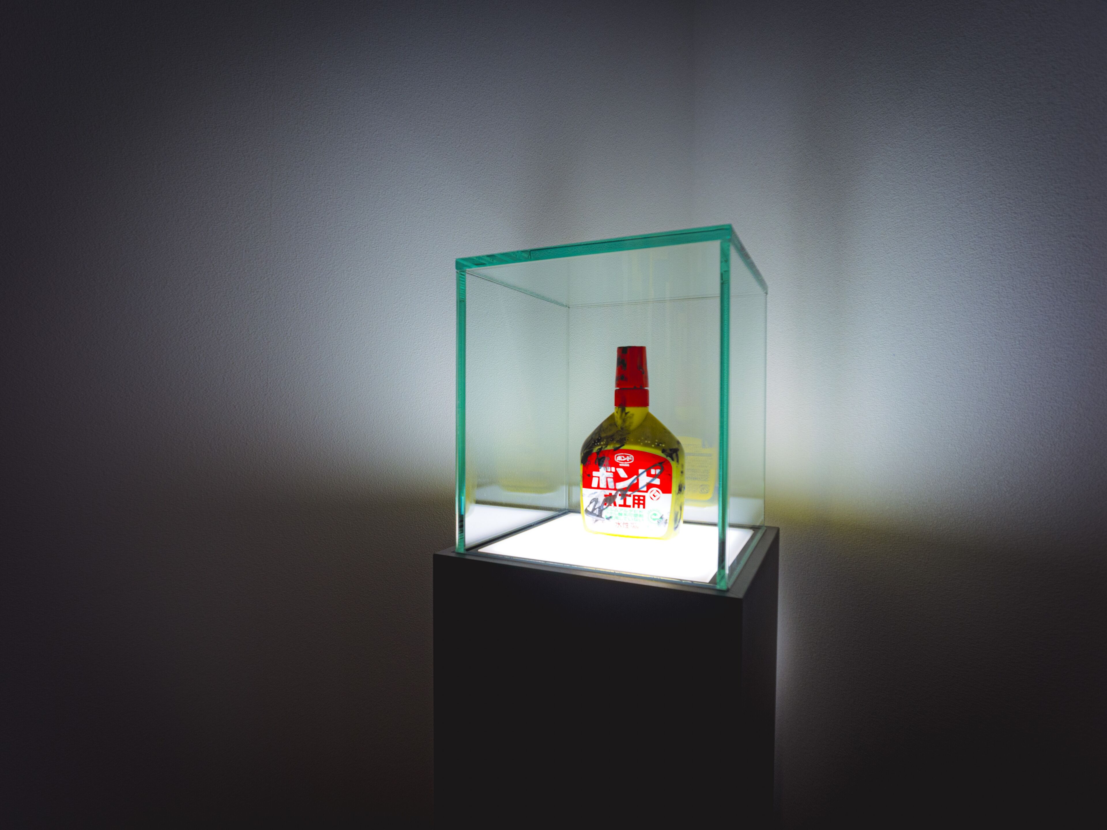 A bottle of liquor in a glass display case.