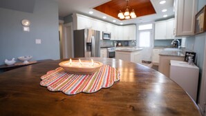 A kitchen with white cabinets, a wooden ceiling, and a dining table with a candle. - Stunning Historic Home in Kanab, Utah. Close proximity to Zion and Bryce Canyon. Incredible stargazing opportunities! (Kanab)