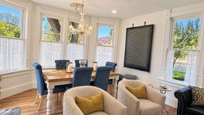 A dining area with a wooden table, blue upholstered chairs, and a chandelier.