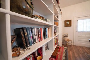 A bookshelf with books and a pair of scissors.