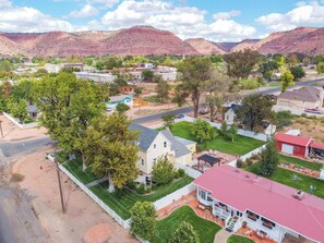 A residential area with houses, a road, and mountains in the background.