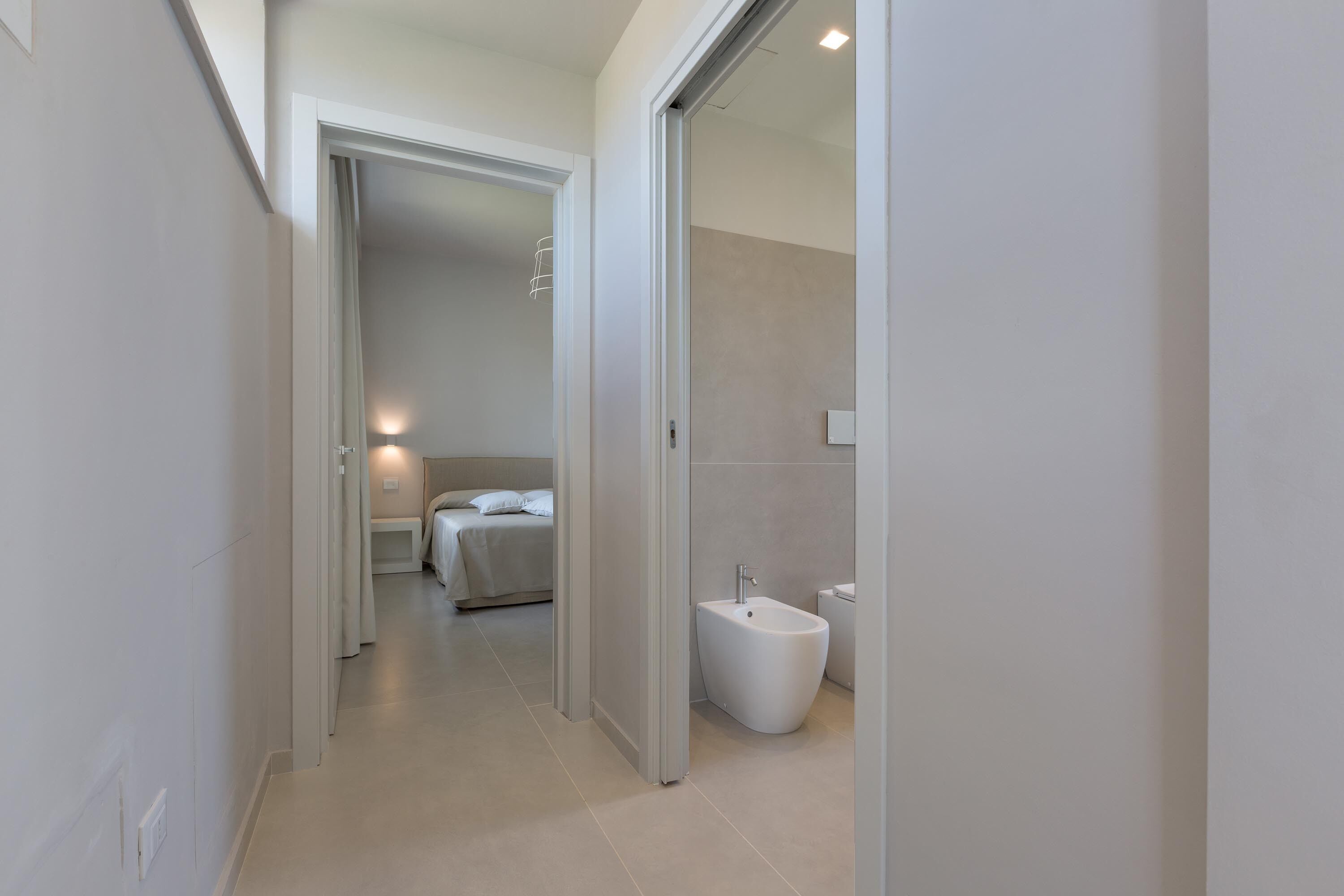 A modern hotel bathroom with a bidet, a toilet, and a shower area.