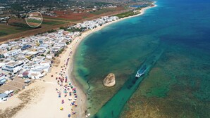 An aerial view of a coastal area with a beach, clear waters, and a small island. - Hotel Perla Saracena - Villette con Giardino (Torre Pali)