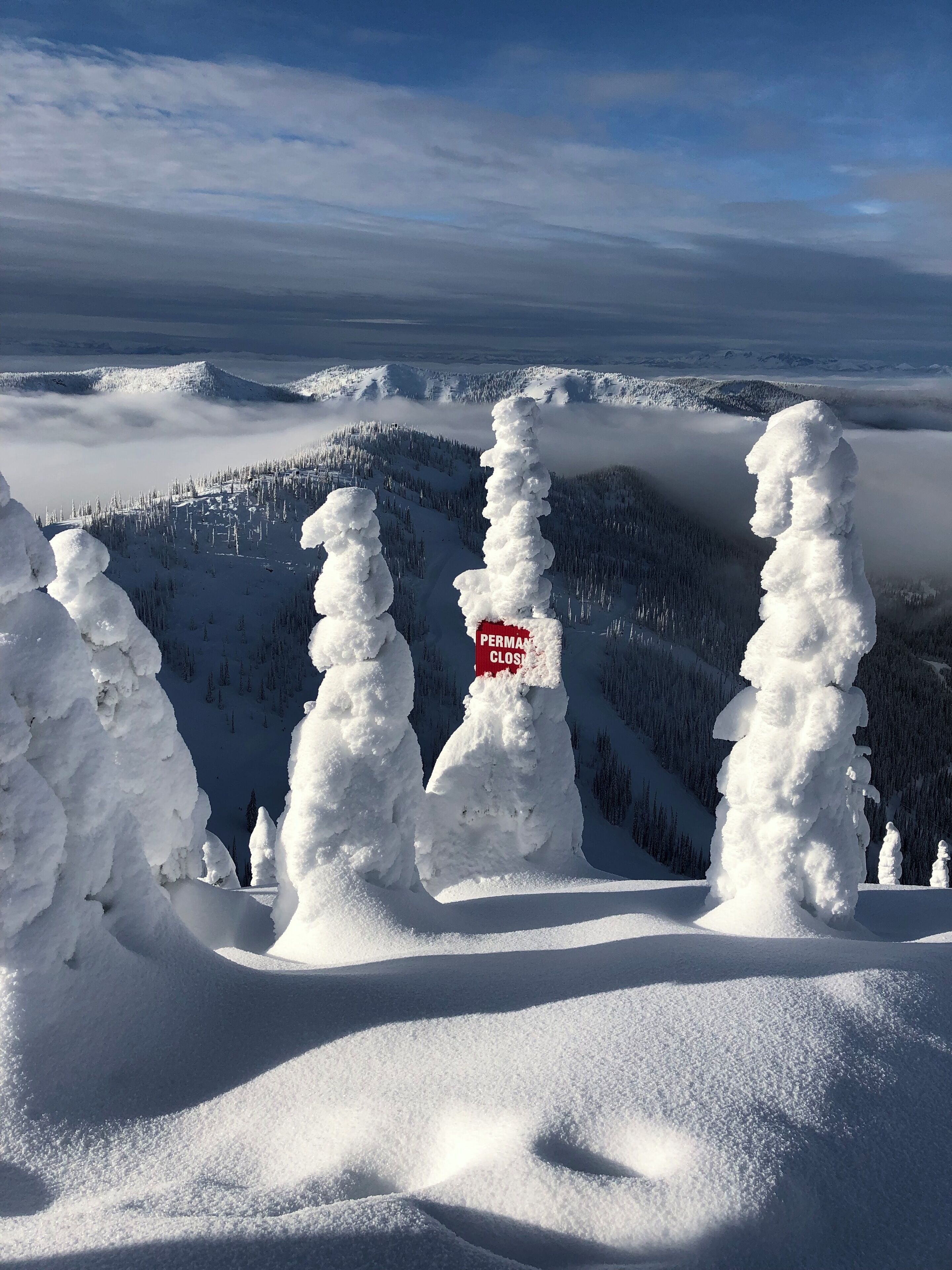 A snow-covered landscape with a sign indicating a permanent closure.