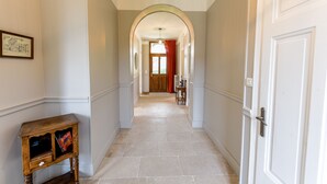 A hallway with a wooden side table, a framed picture on the wall, and a door at the end. - 5 bedroom house in Annecy between town and countryside ⭐⭐⭐ (Seynod)