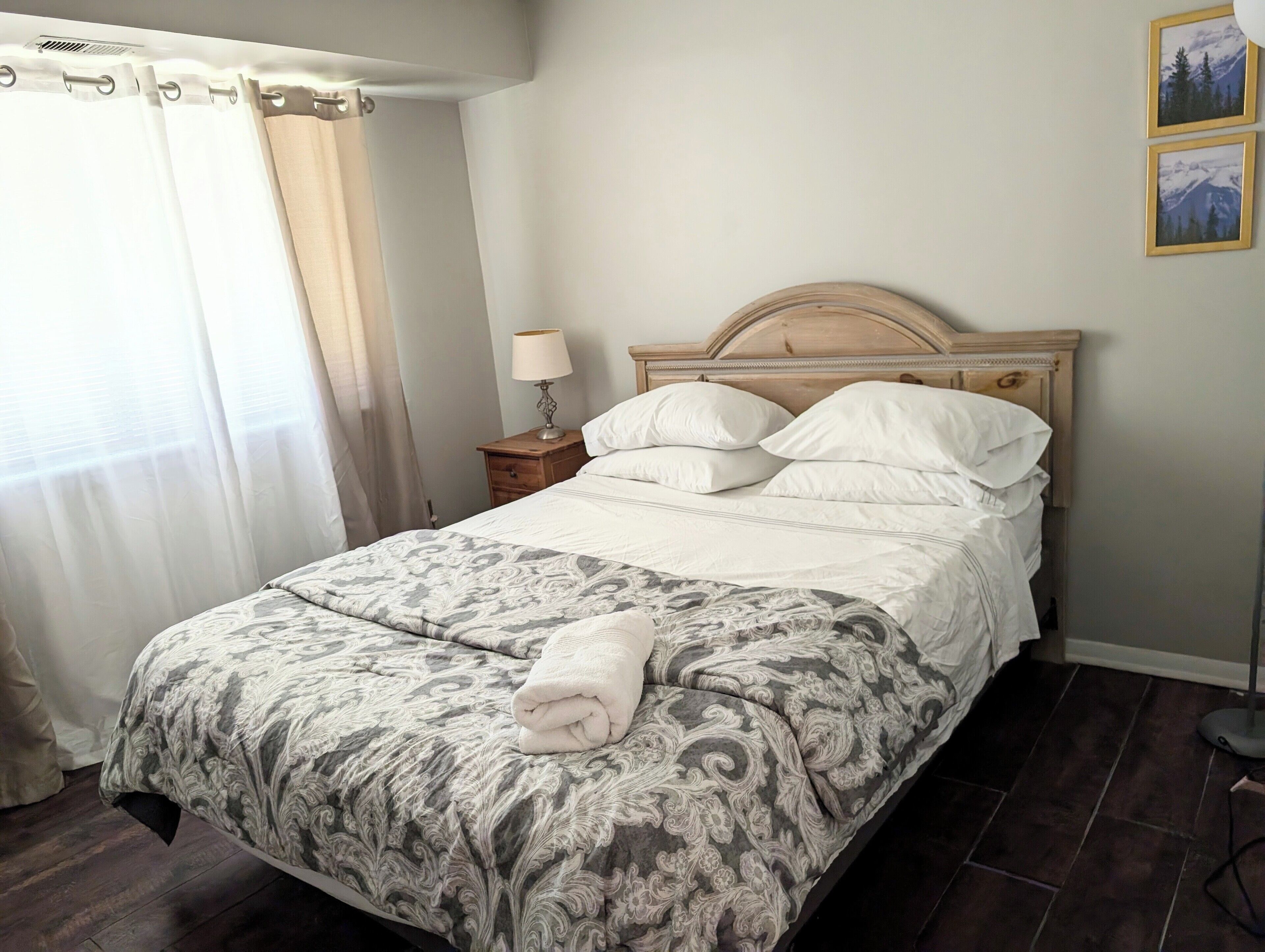 A neatly made bed with a patterned bedspread, a bedside lamp, and a headboard.
