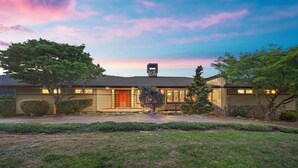 A two-story house with a red door, a chimney, and a well-maintained lawn. - Frank Lloyd Wright-styled Mid-Century Modern Retreat on 5 Private Acres (Rabun Gap)