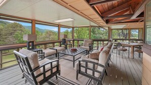 A spacious deck with outdoor furniture, large windows, and a view of the surrounding landscape. - Frank Lloyd Wright-styled Mid-Century Modern Retreat on 5 Private Acres (Rabun Gap)