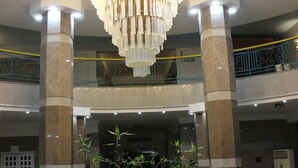 A lobby with a large chandelier, a central table with chairs, and a staircase leading to an upper level. - Grand Blue St Maria Hotel & Aqua Park (Hurghada)