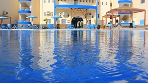 A hotel with a pool, blue chairs, umbrellas, and a restaurant entrance. - Grand Blue St Maria Hotel & Aqua Park (Hurghada)