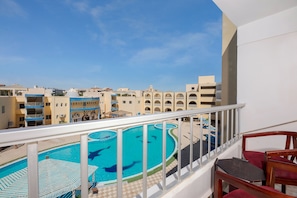 A pool area with a clear blue sky, a pool with a dolphin sculpture, and a balcony with a railing. - Grand Blue St Maria Hotel & Aqua Park (Hurghada)