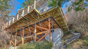 A wooden deck with a stone staircase leading up to a building.