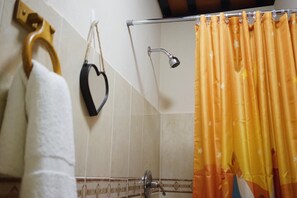 A bathroom with a shower, a towel rack, and a curtain. - Esthelar Lodging (San Juan)