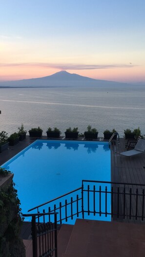 Une piscine avec vue sur la montagne et la mer.