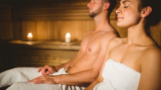 A couple in a spa setting with wooden walls and candles. - Hotel World of Harmony (Lánov)