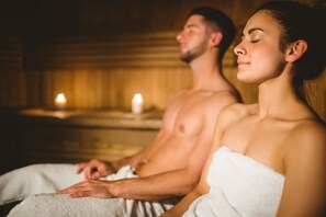 A couple in a spa setting with wooden walls and candles. - Hotel World of Harmony (Lánov)