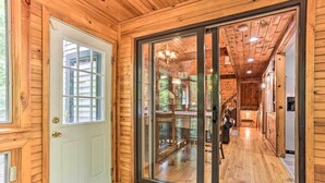 A wooden interior with a sliding glass door leading to a deck.