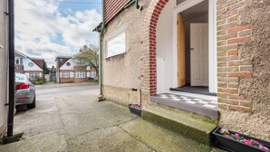 Una propiedad residencial con camino de entrada pavimentado, puerta de garaje y fachada de ladrillo.