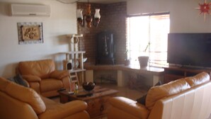 Ein Wohnzimmer mit einer Sofagarnitur, einem Couchtisch und einem Fernseher.