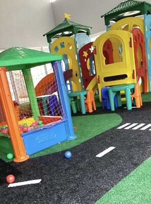 Een kinderspeelruimte met een bällebad, klimconstructies en een klein zitgedeelte.