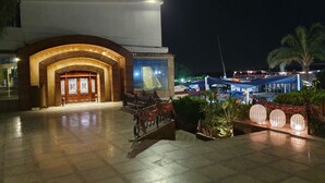 Entrada de hotel con un arco imponente, un mostrador de recepción y un cartel.
