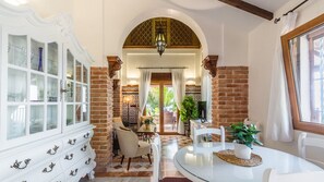 Enjoy a warm and inviting space with a traditional design, featuring a round dining table and comfortable seating.