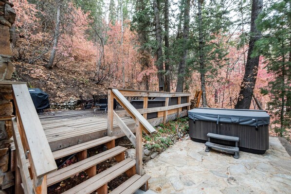A wooden deck with a hot tub and a barbecue grill in a forested area. - 2 Bdrm w/Loft Walk to Ski Run Hot Tub Fireplace (Sundance)