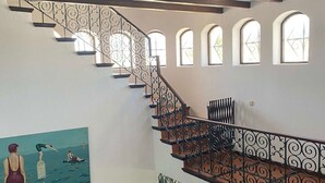 Una scala con ringhiere in metallo decorate e un dipinto raffigurante un nuotatore sulla parete.