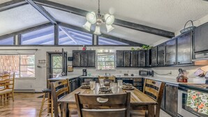 Una cocina amplia con una gran mesa de comedor, armarios de madera oscura y un tragaluz.