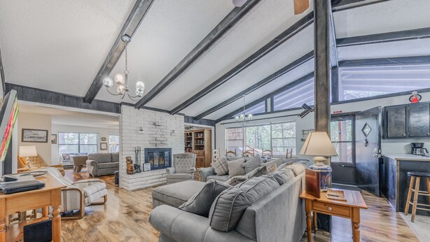 Una sala de estar amplia con chimenea, comedor y cocina.