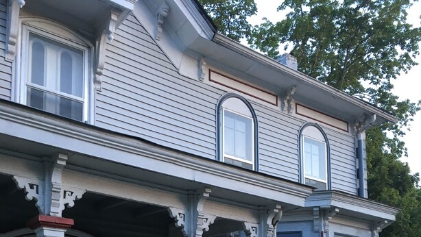 A two-story house with a porch, white siding, and decorative trim. - Historic Victorian - 1 Hour N of Nashville (Russellville)