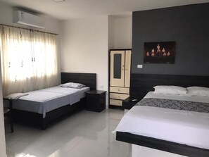 A hotel room with two beds, a wardrobe, a desk, and a wall-mounted air conditioner. - Hostería Pacific Stone (Tachina)