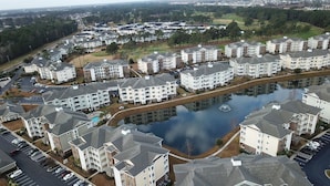 Ett bostadsområde med hyreshus, en parkeringsplats och en vattenyta.